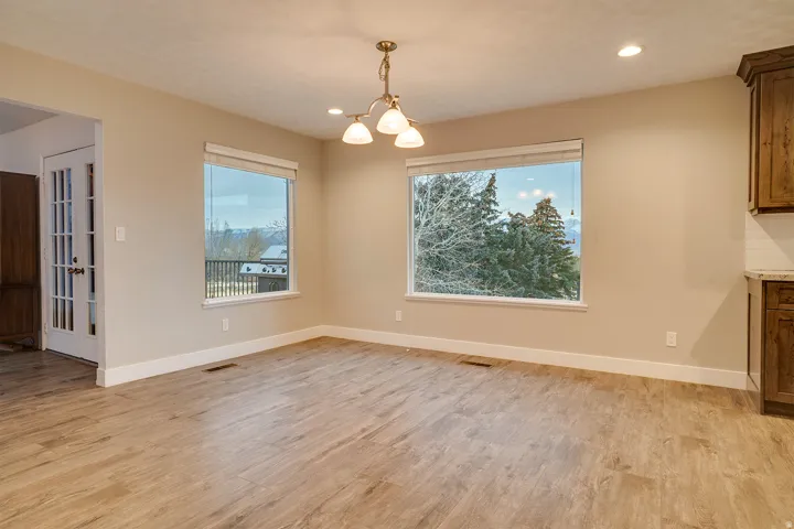 Spacious room featuring wood-finish flooring, neutral-toned walls, and recessed lighting