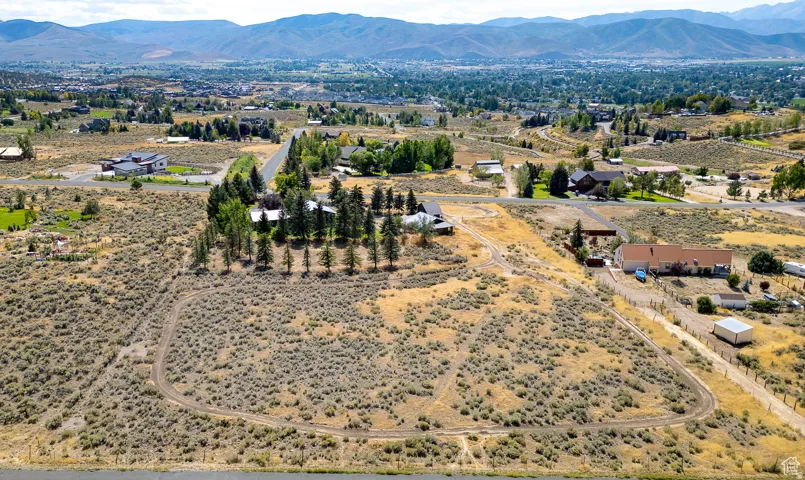Expansive undeveloped land featuring natural high desert vegetation and a visible perimeter track