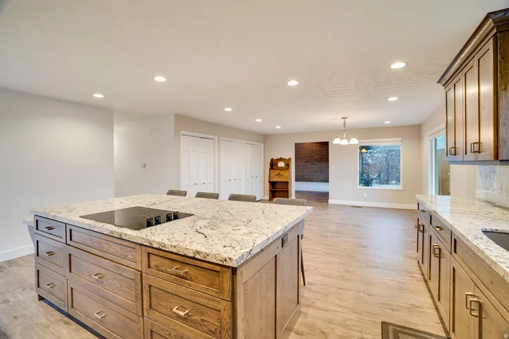 Spacious kitchen island with a built-in cooktop and stone-finish countertop