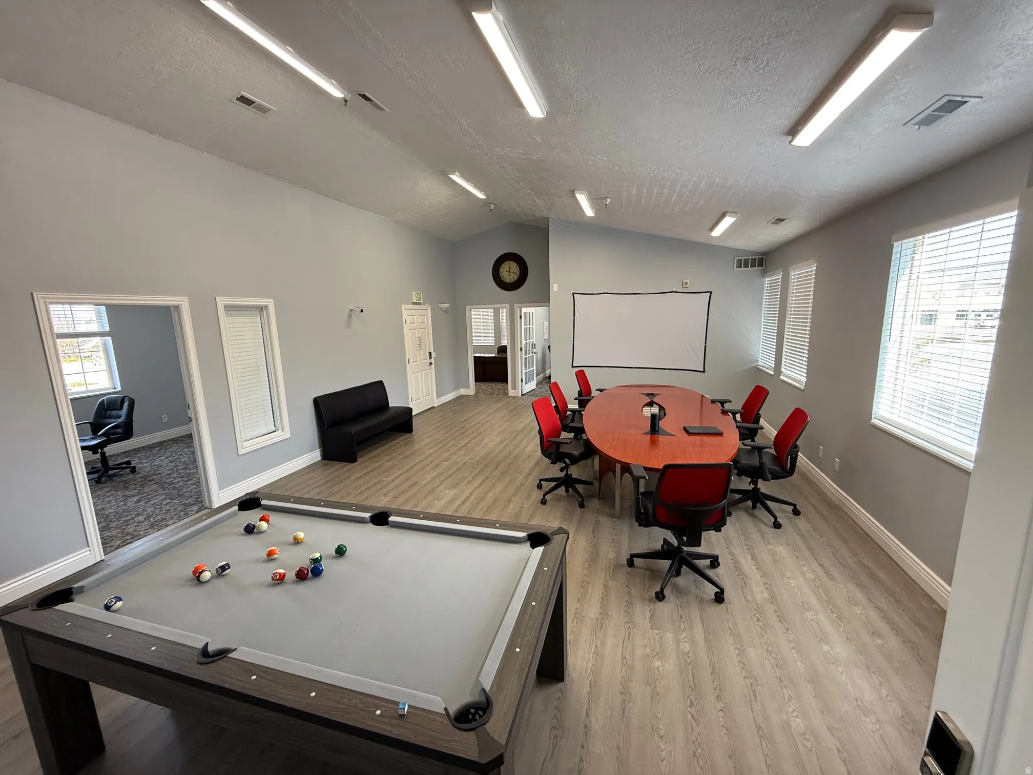 Spacious common area featuring wood-finish flooring, vaulted ceilings, and recessed lighting