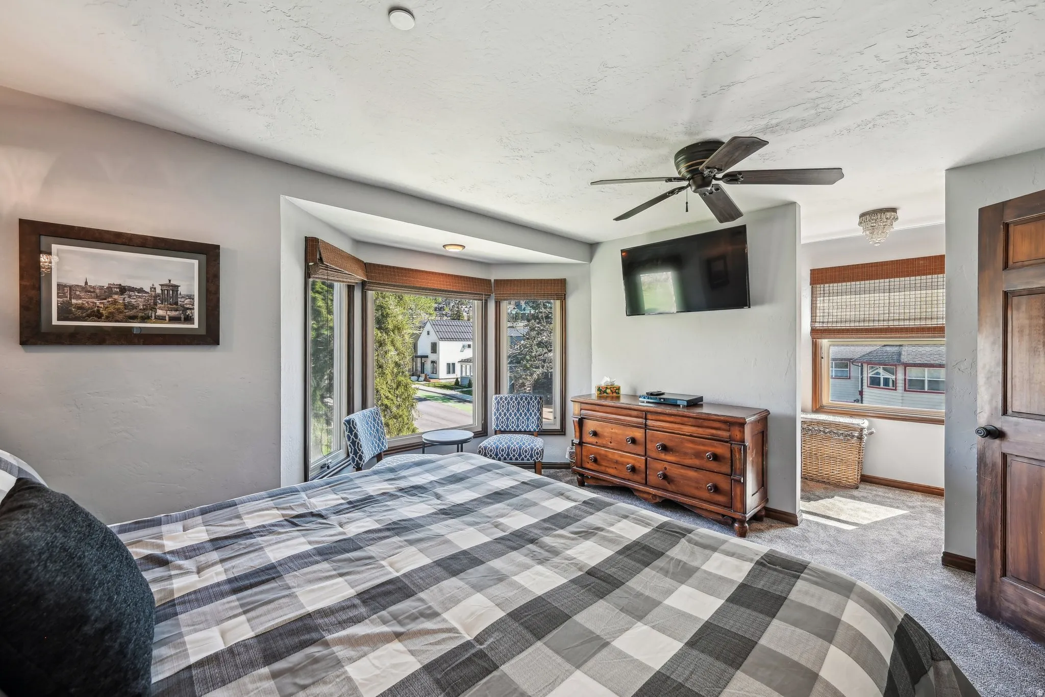 Bedroom with carpet floors, ceiling fan, and a textured ceiling