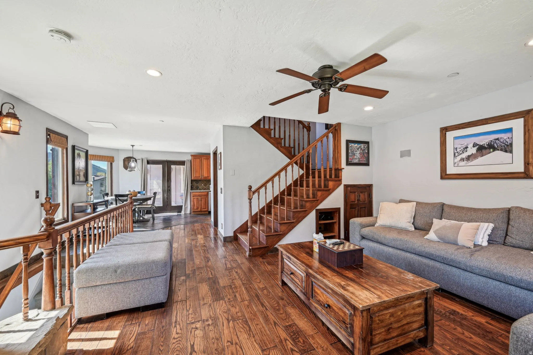 Living room with dark wood-type flooring, ceiling fan, and recessed lighting