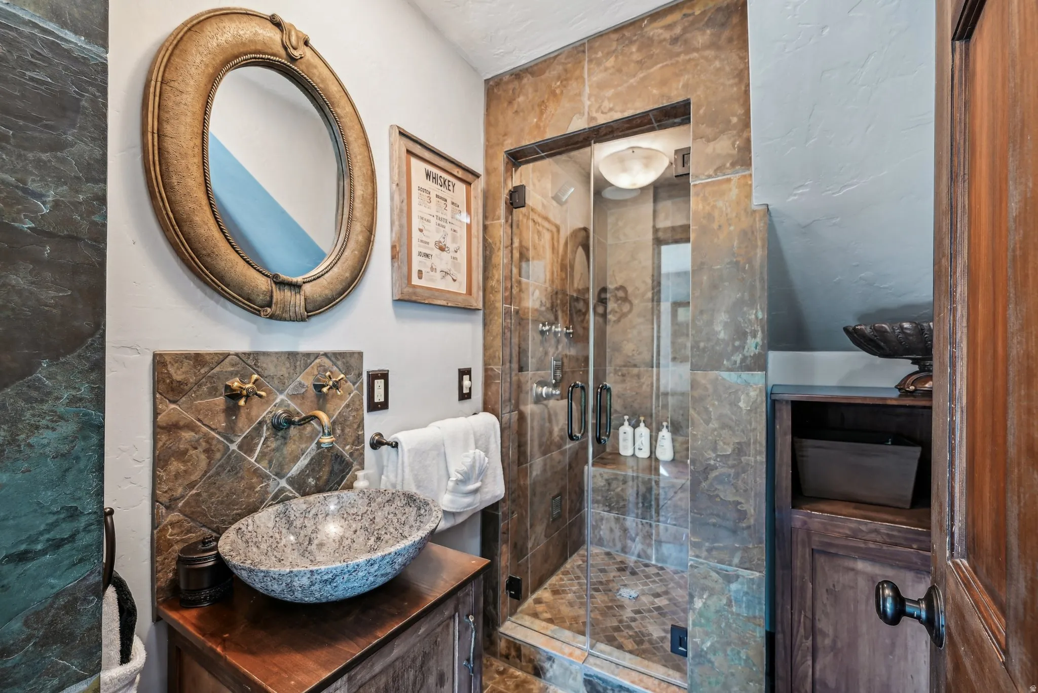 Full bath with vanity, a stall shower, and tile walls
