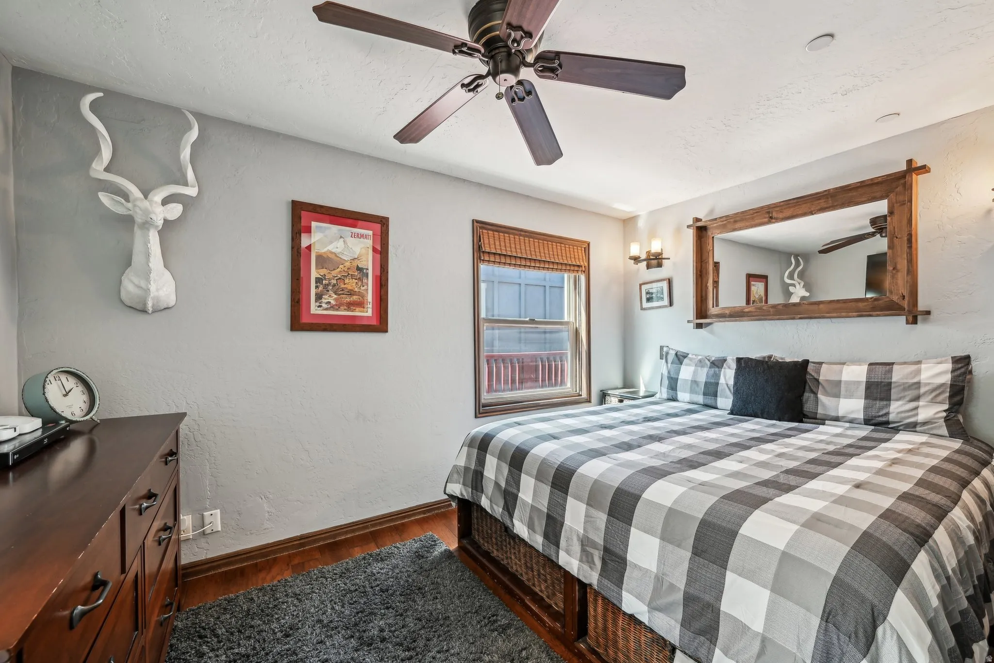 Bedroom with a textured wall, dark wood-type flooring, a ceiling fan, and a textured ceiling