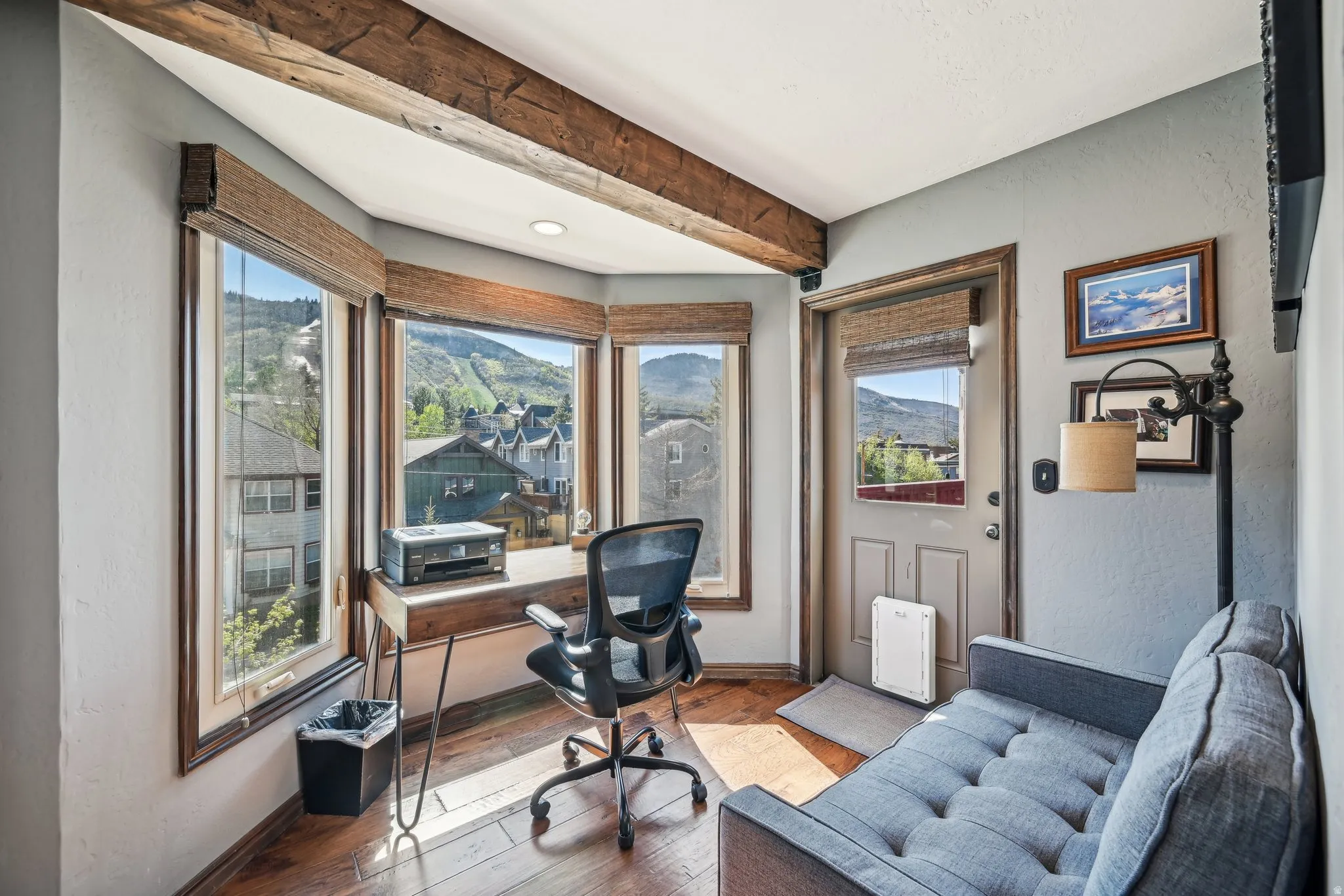 Office area with a textured wall, hardwood / wood-style flooring, a mountain view, and beamed ceiling