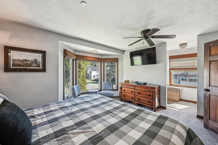 Bedroom with carpet floors, ceiling fan, and a textured ceiling