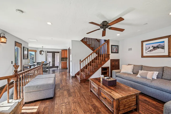 Living room with dark wood-type flooring, ceiling fan, and recessed lighting