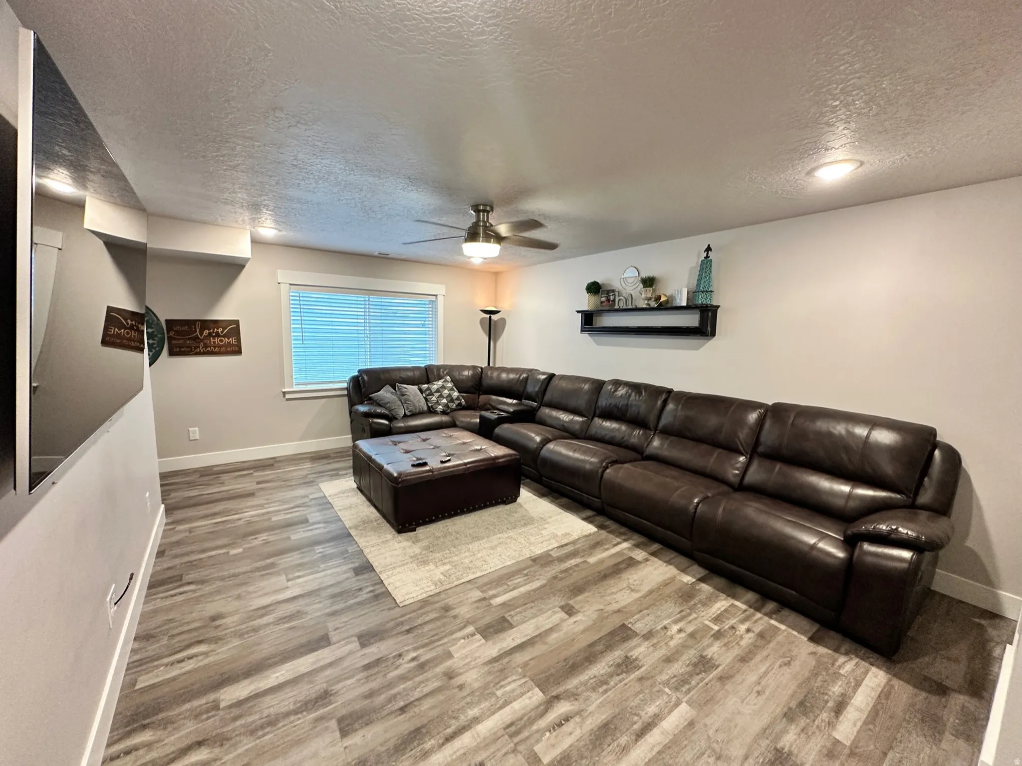 Spacious room featuring wood-finish flooring, recessed lighting, and a ceiling fan