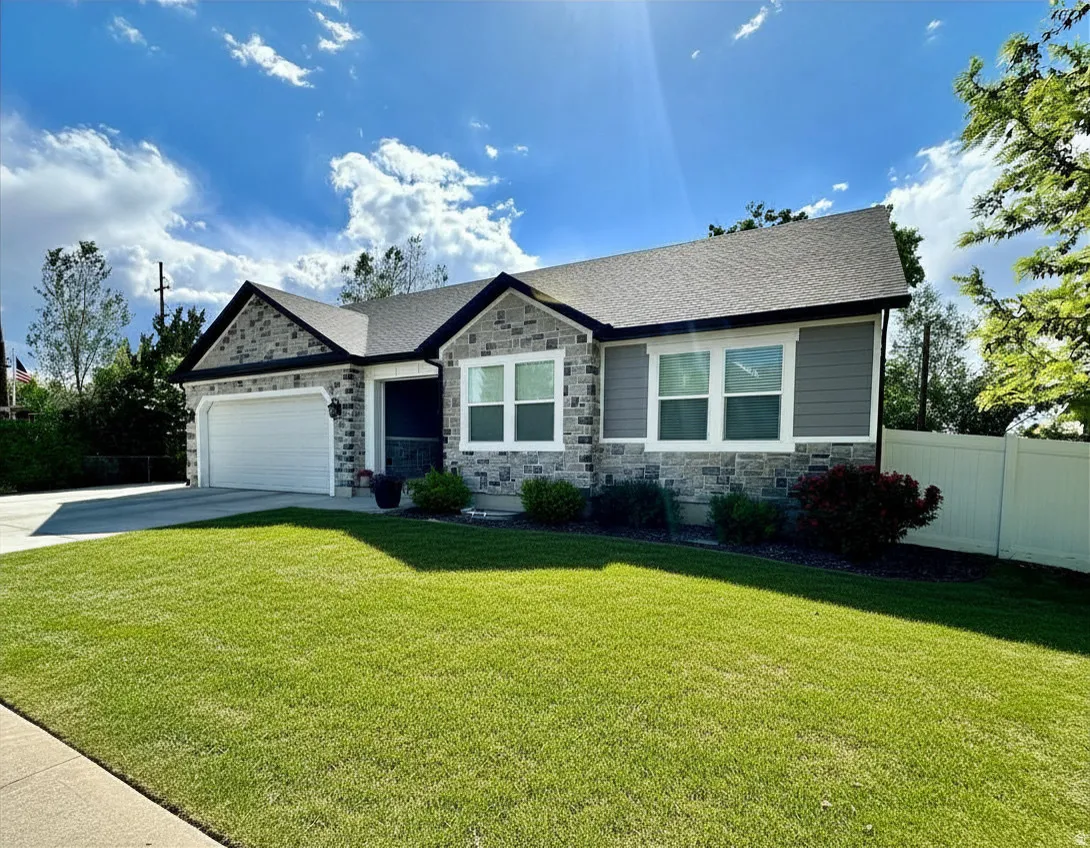 Stone veneer and horizontal siding exterior featuring white trim windows