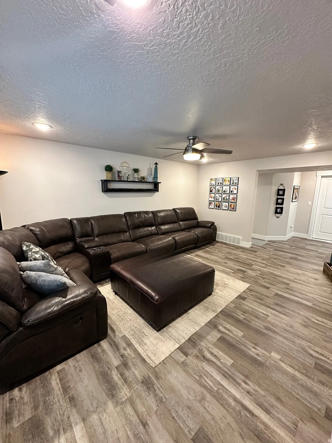 Spacious living area featuring wood-finish flooring, recessed lighting, and a ceiling fan