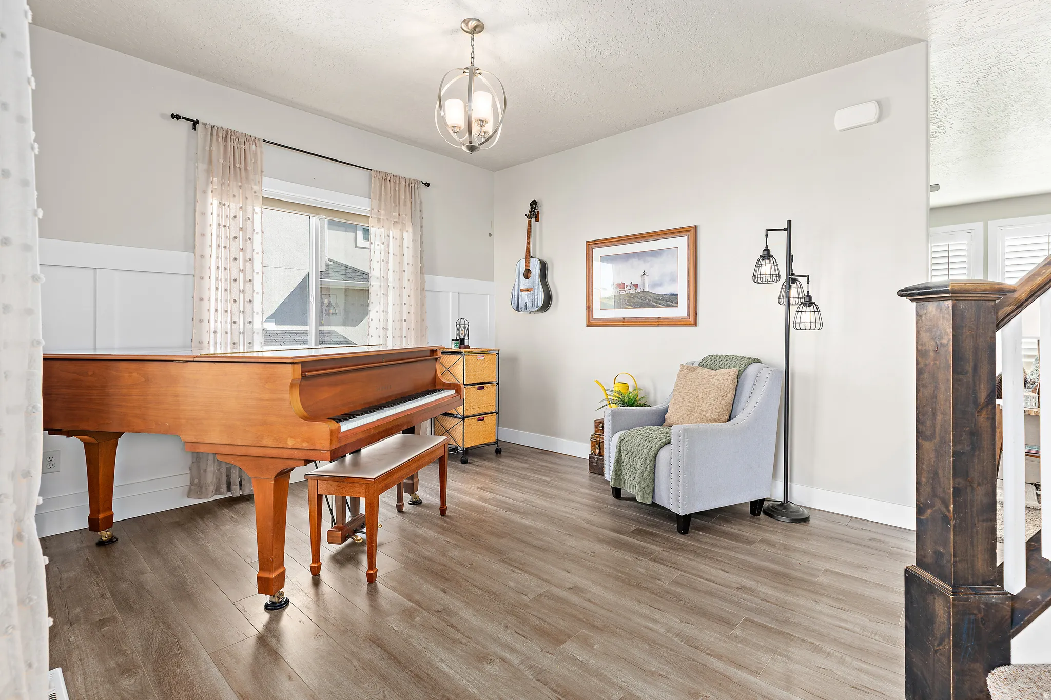 Entryway featuring wood-finish flooring, wainscoting, and a prominent window