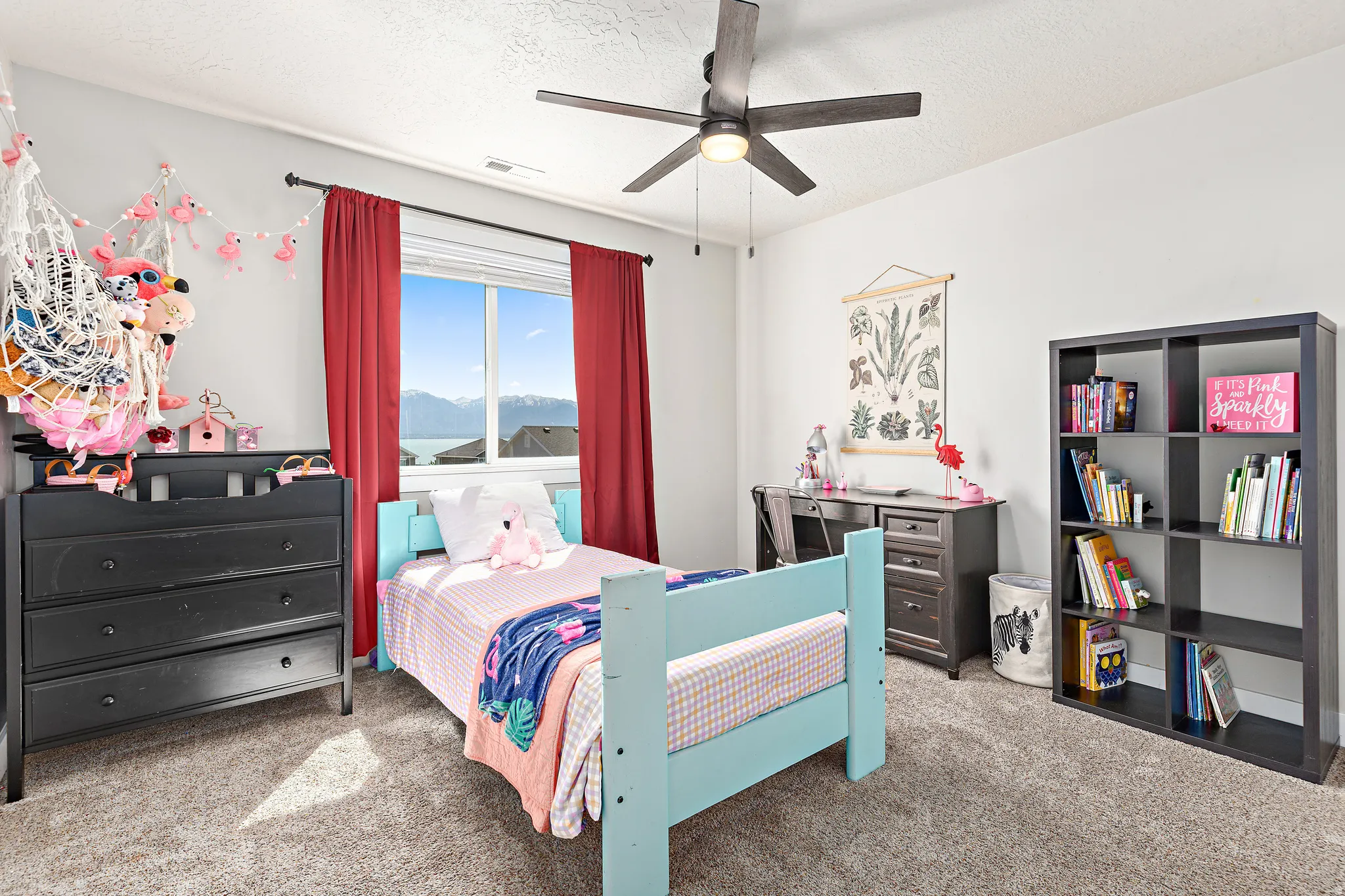 Carpeted room featuring a ceiling fan with integrated lighting, a large window with white trim, and light-toned walls