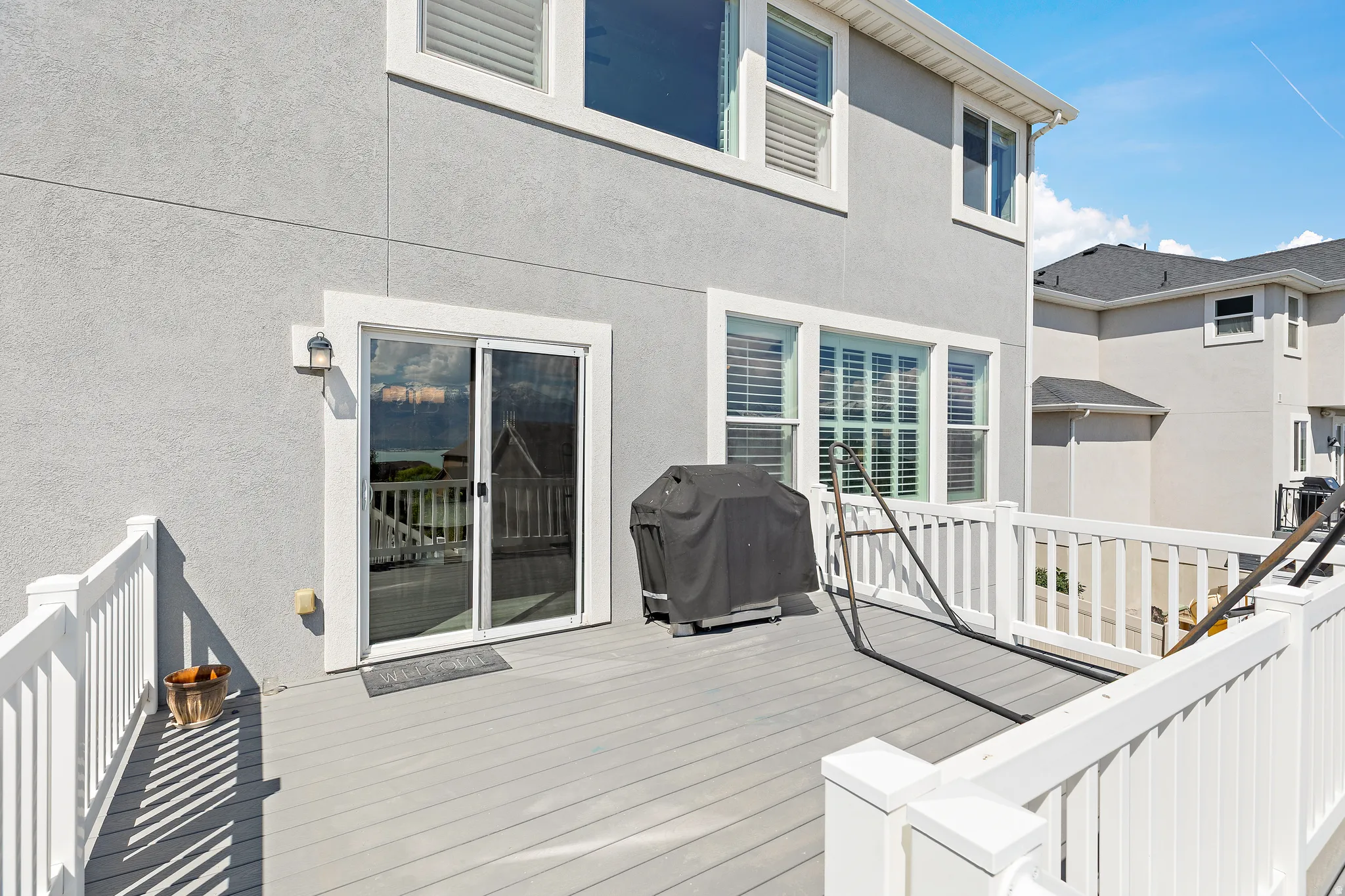 Upper-level deck featuring a gray composite surface and white railings