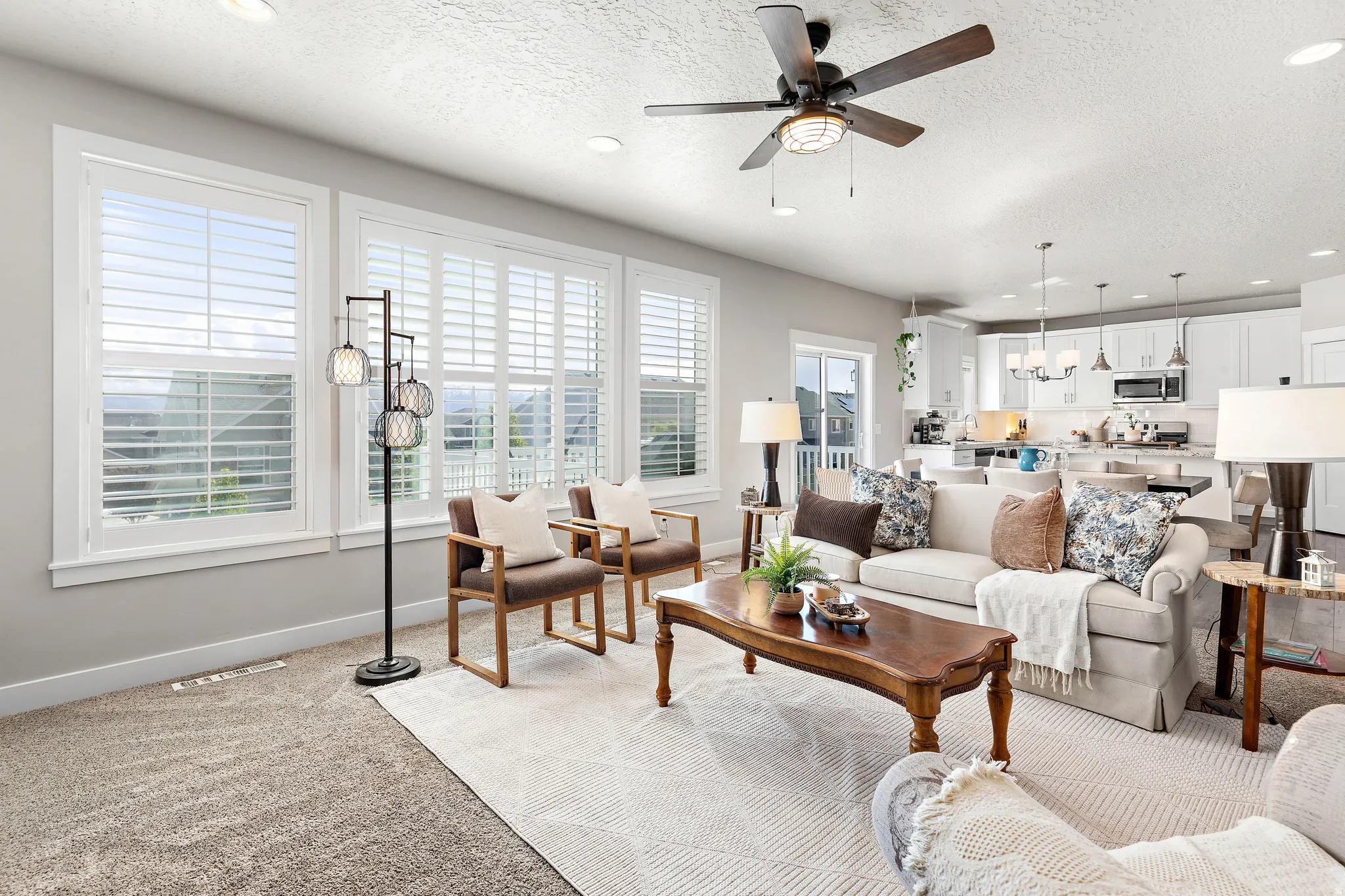 Open-concept living space featuring light gray walls and a textured ceiling