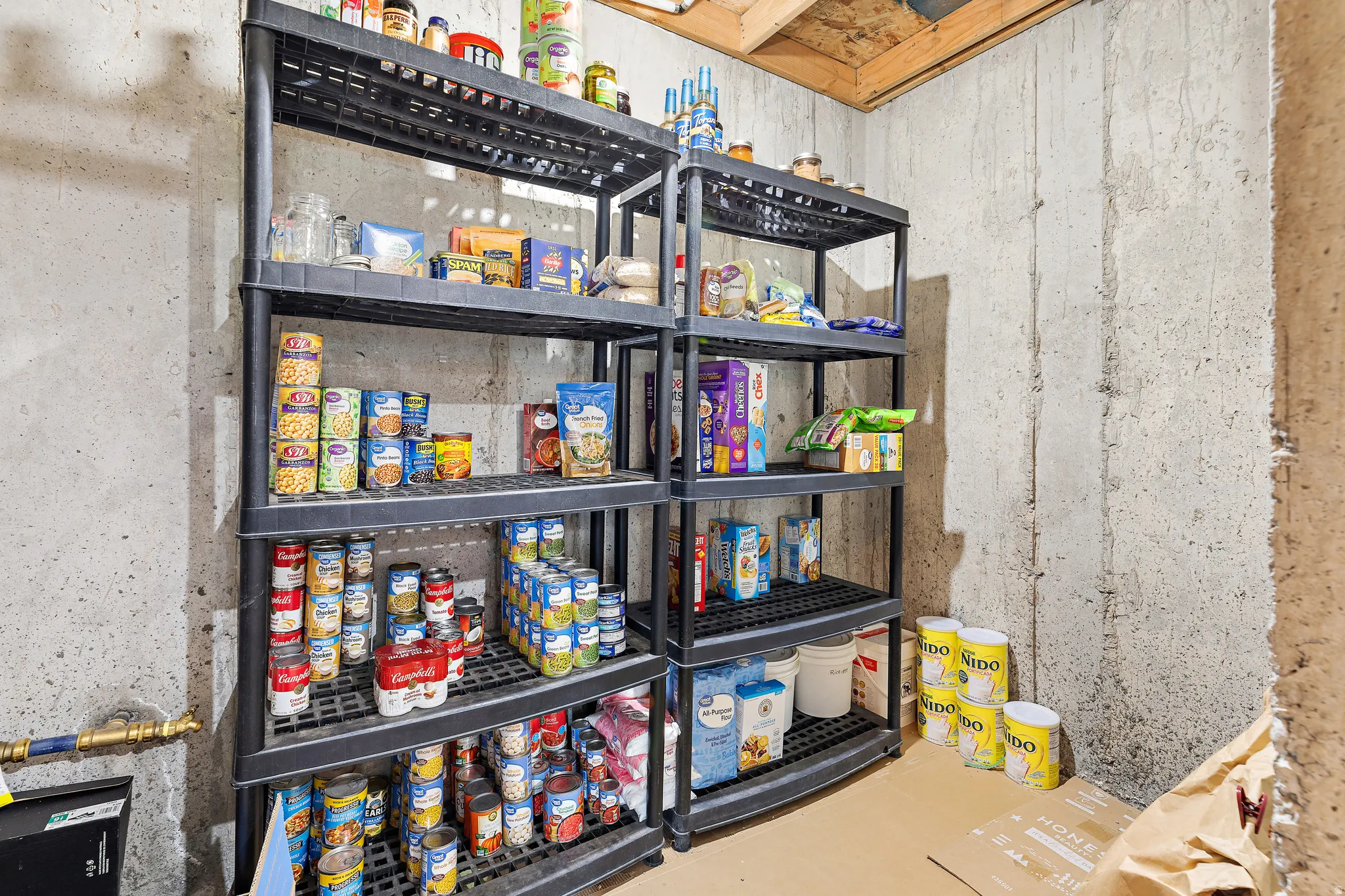 Concrete wall with a storage system featuring multiple black plastic shelving units