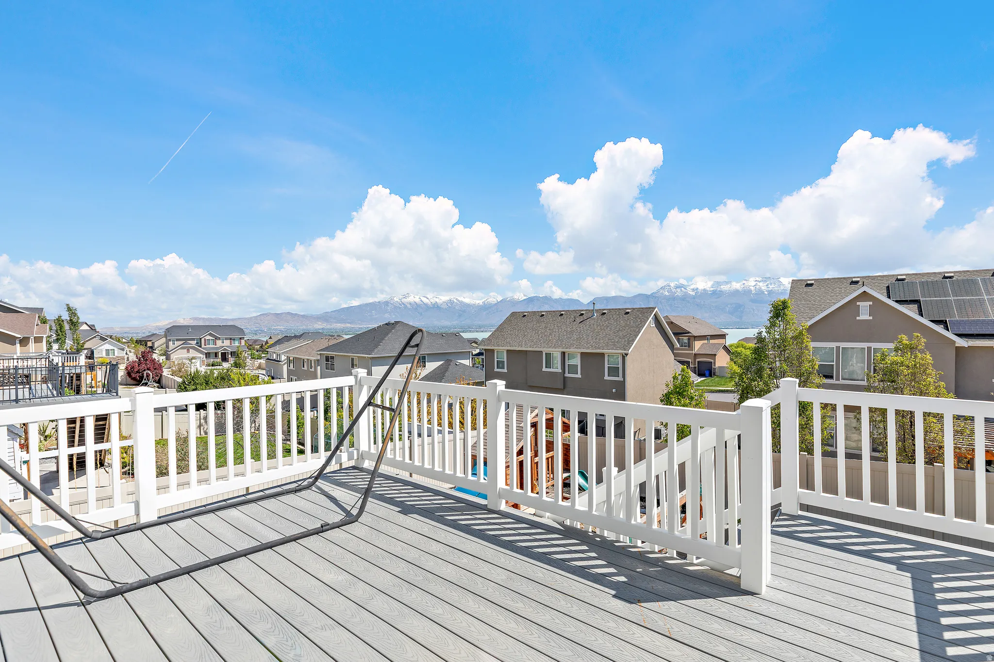 Expansive outdoor deck featuring wood-finish flooring and white perimeter railing