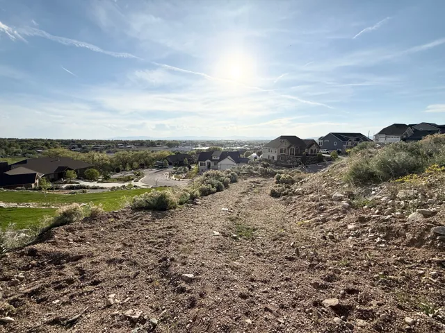 Sloping terrain with natural ground cover, offering a broad perspective of the surrounding area