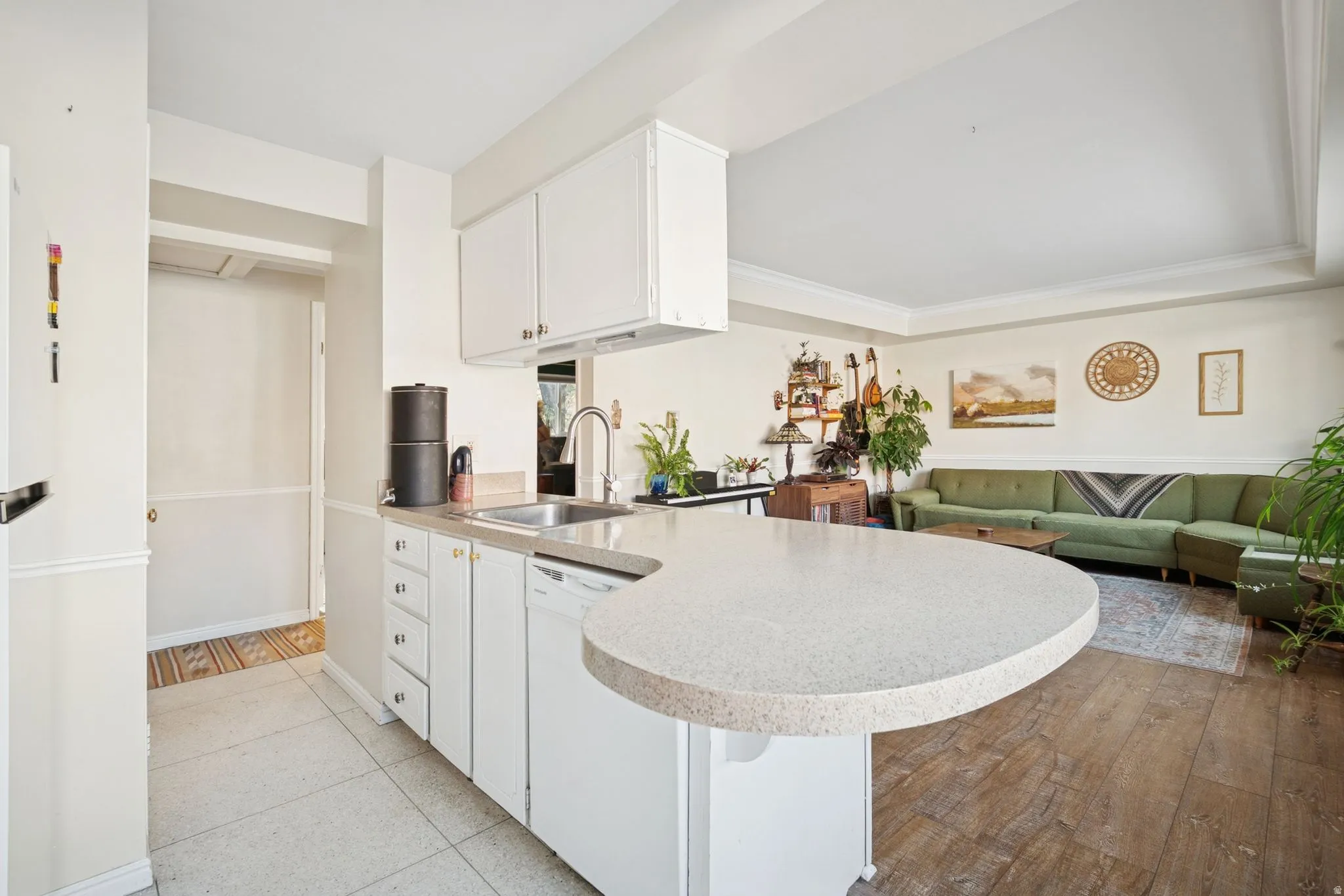 Kitchen with a peninsula, white cabinets, dishwasher, and open floor plan