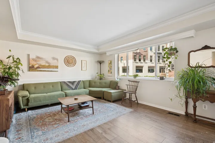 Living area featuring light wood-type flooring and ornamental molding