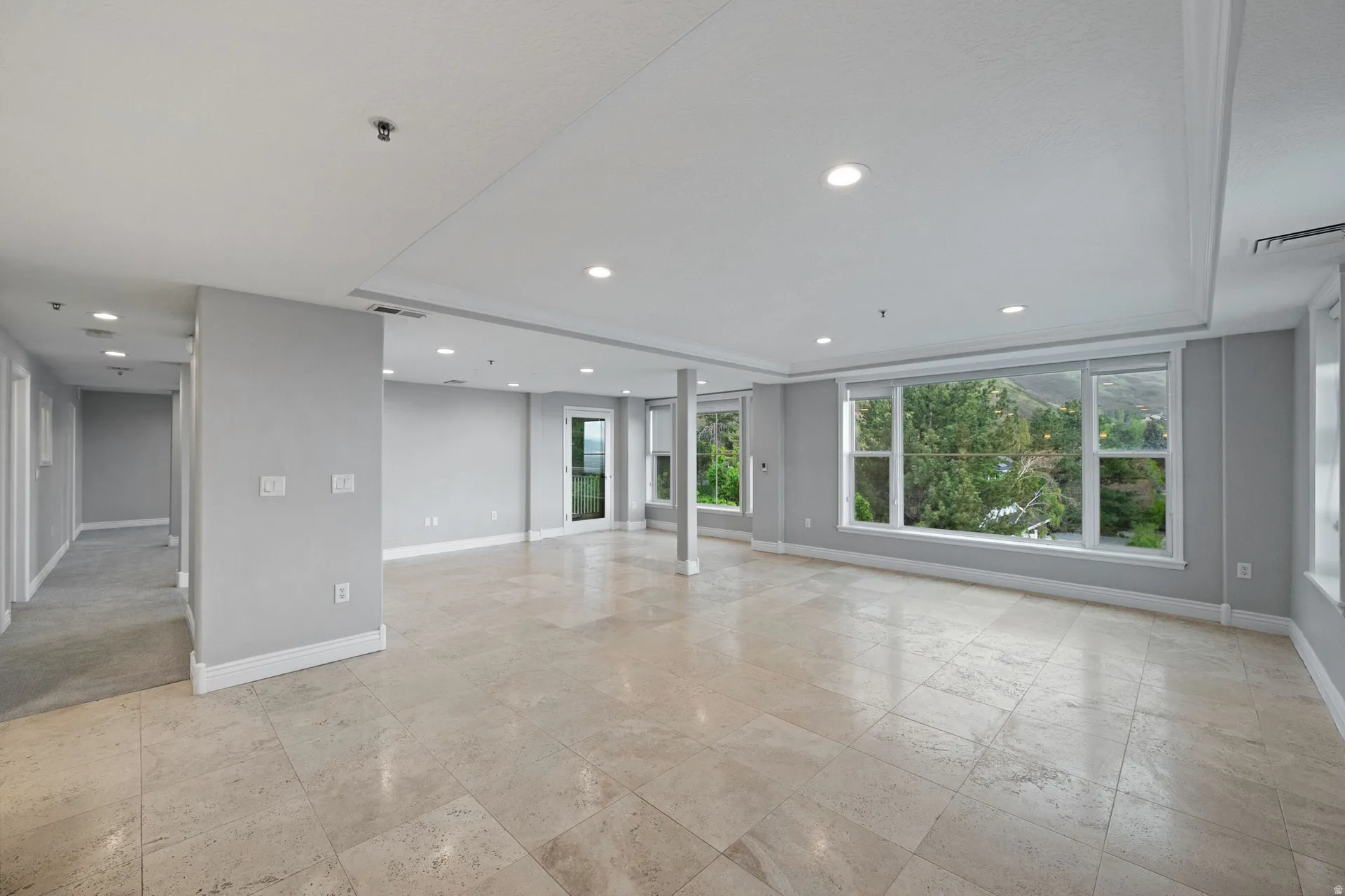 Unfurnished living room with recessed lighting and a tray ceiling
