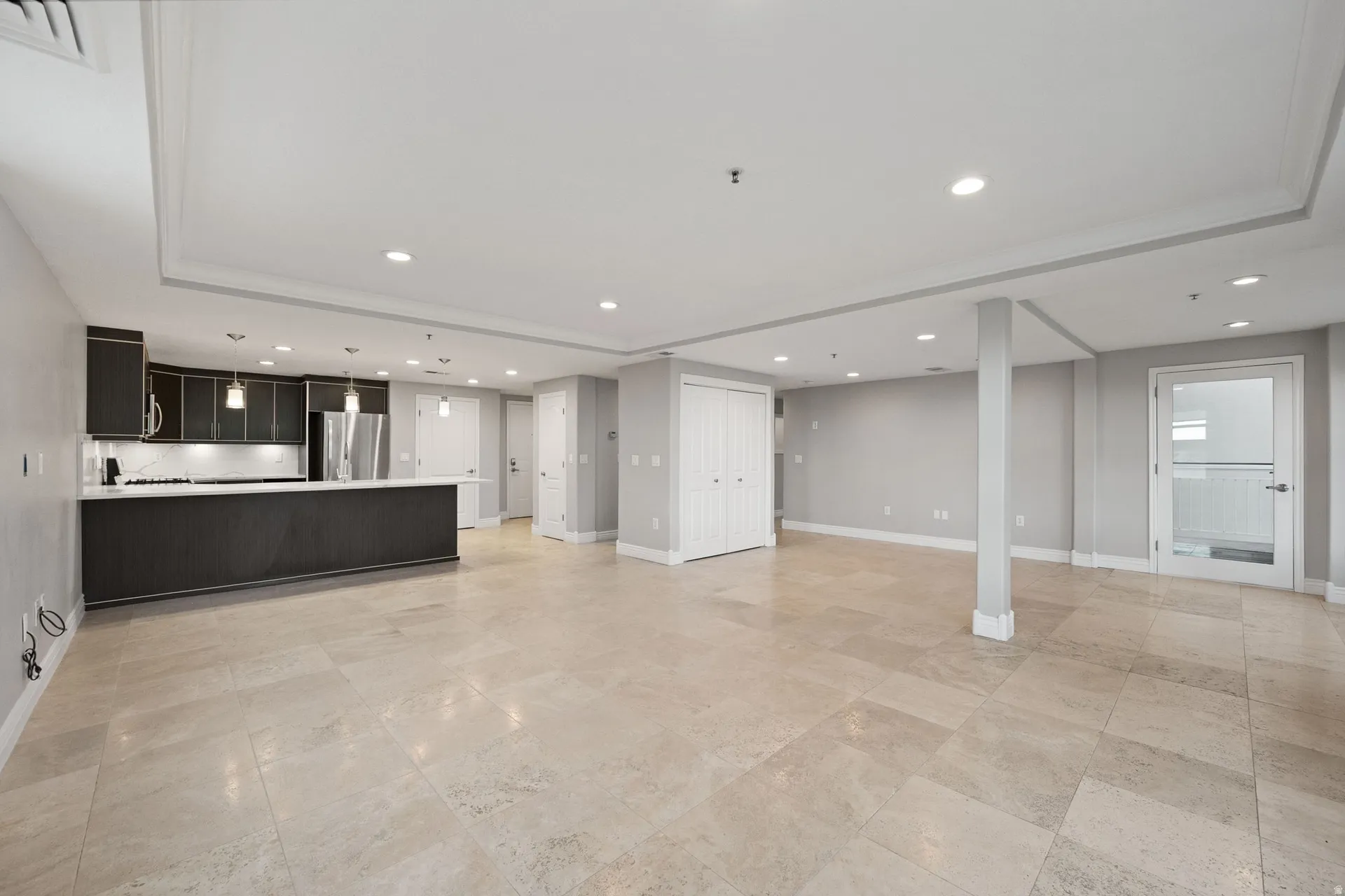 Unfurnished living room with a raised ceiling and recessed lighting