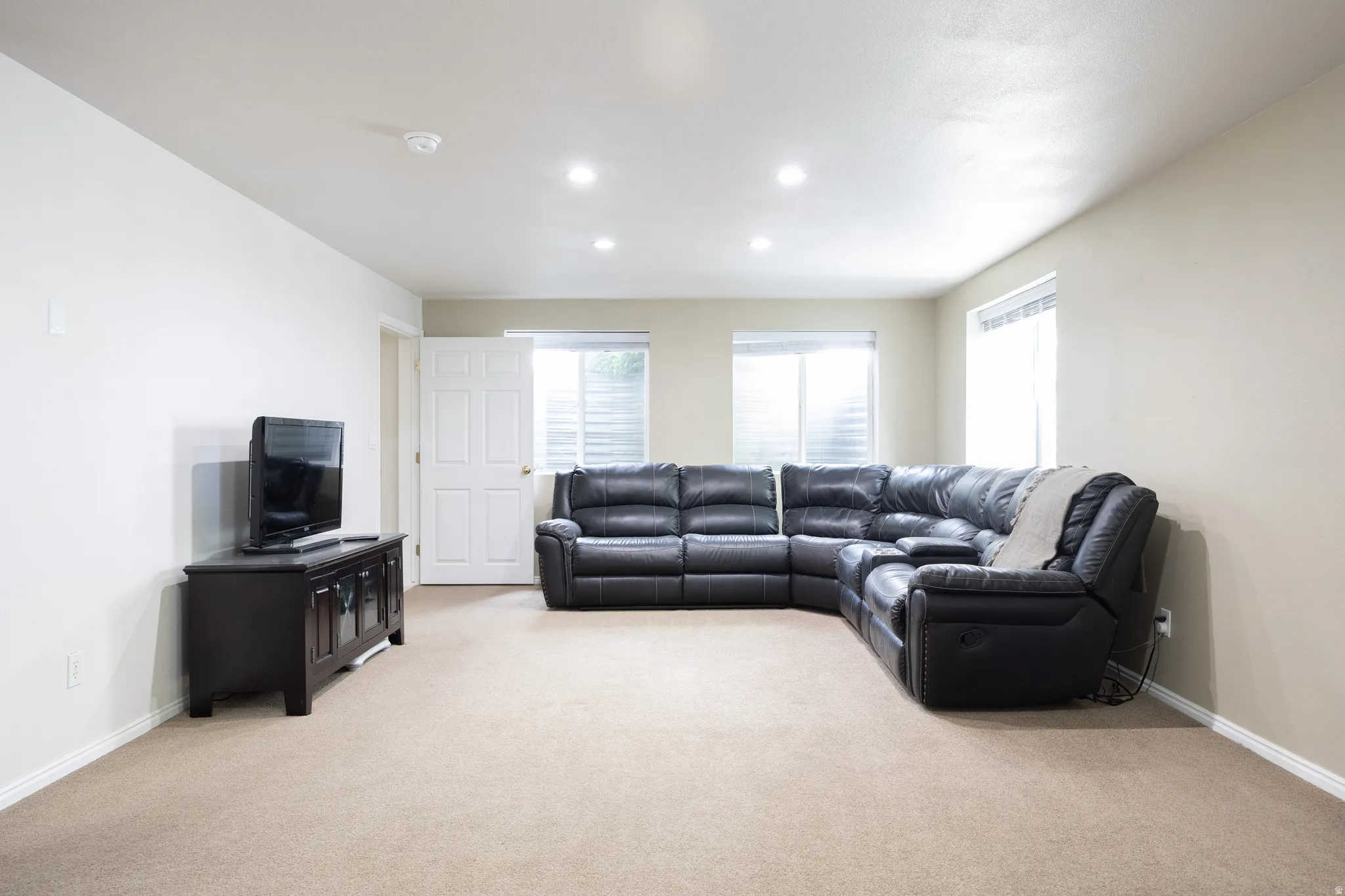 Spacious room featuring neutral carpeting and light-toned walls
