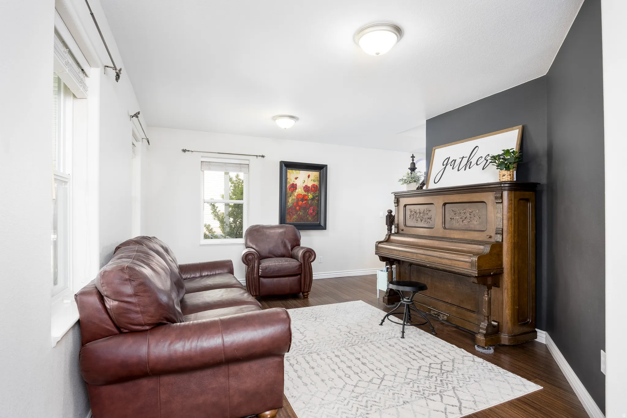 Bright room featuring wood-finish flooring, white walls, and a contrasting dark accent wall