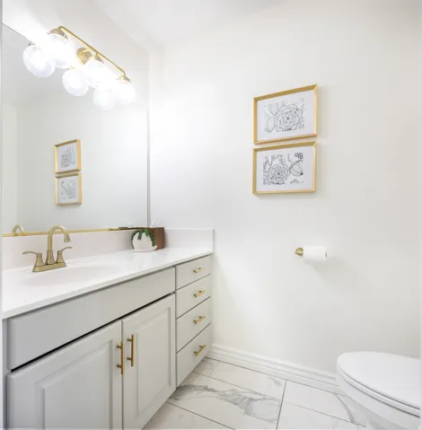 Bathroom featuring a vanity with white cabinetry, gold-tone hardware, and a white countertop