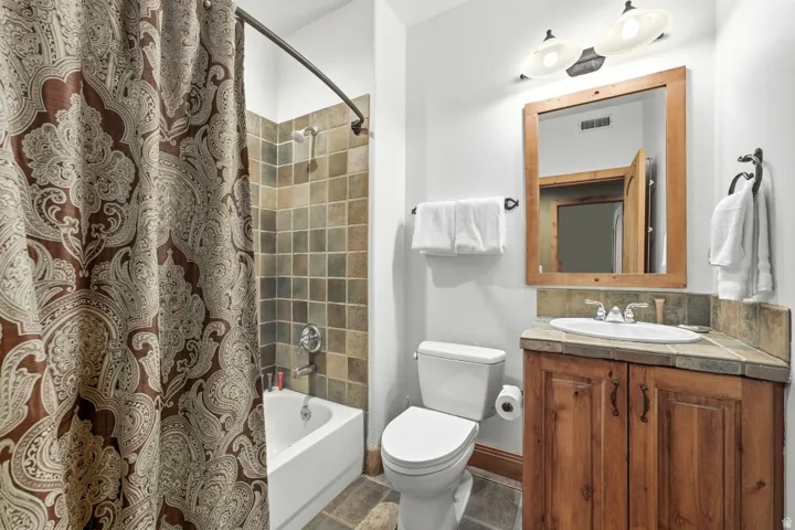 Bathroom featuring vanity and shower / bath combination with curtain