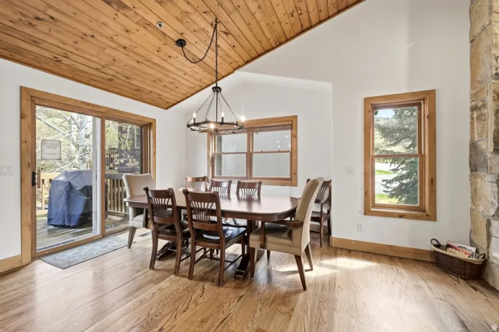 Dining area featuring a chandelier, light wood-style flooring, and a vaulted wooden ceiling