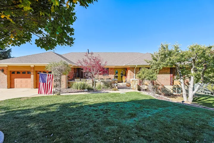 Ranch-style house with brick siding, a front lawn, an attached garage, and roof with shingles