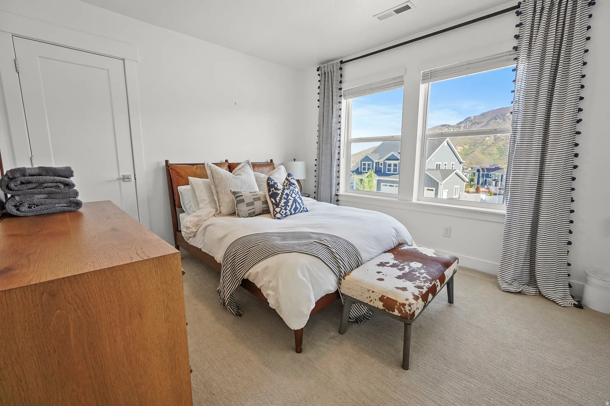 Bedroom with light carpet and a mountain view
