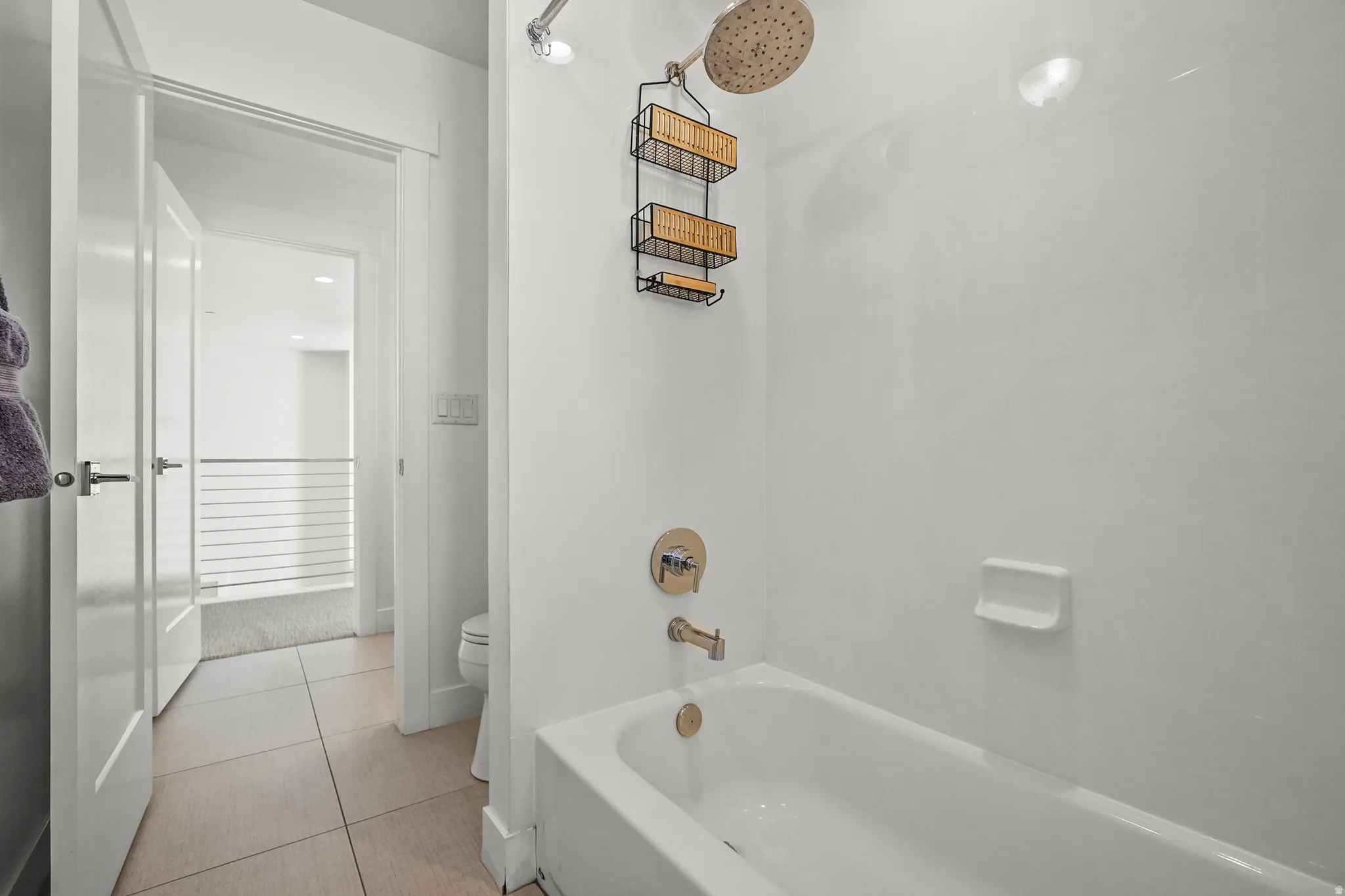 Full bathroom featuring light tile patterned floors and shower / washtub combination