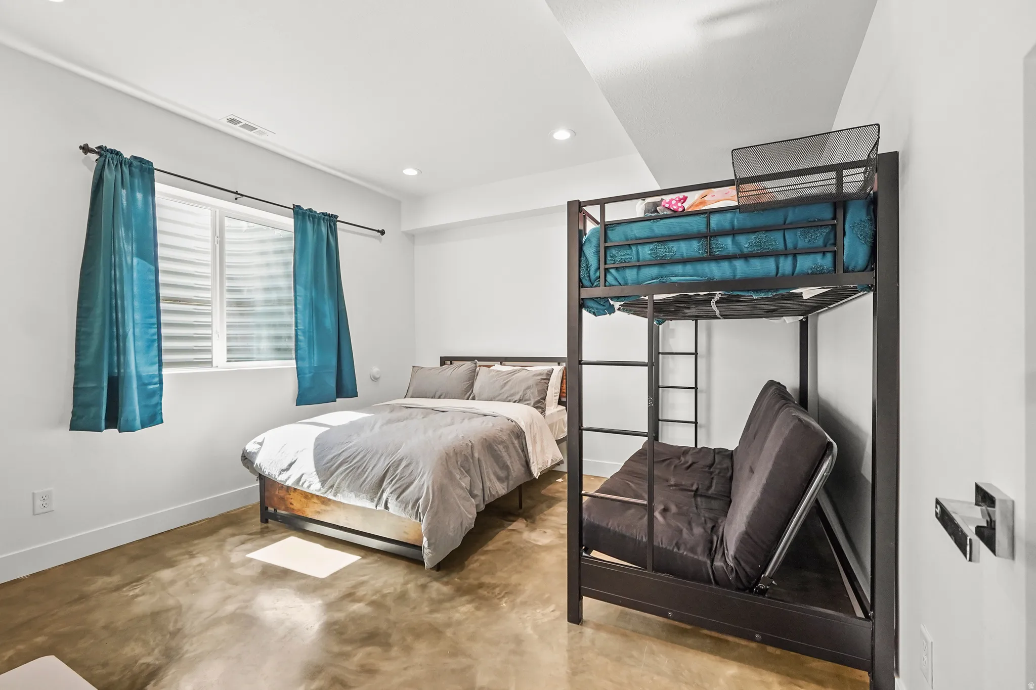 Bedroom featuring concrete flooring and recessed lighting