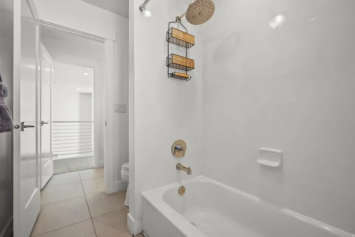 Full bathroom featuring light tile patterned floors and shower / washtub combination