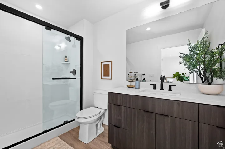 Full bath featuring vanity, a shower stall, light wood-style floors, and recessed lighting