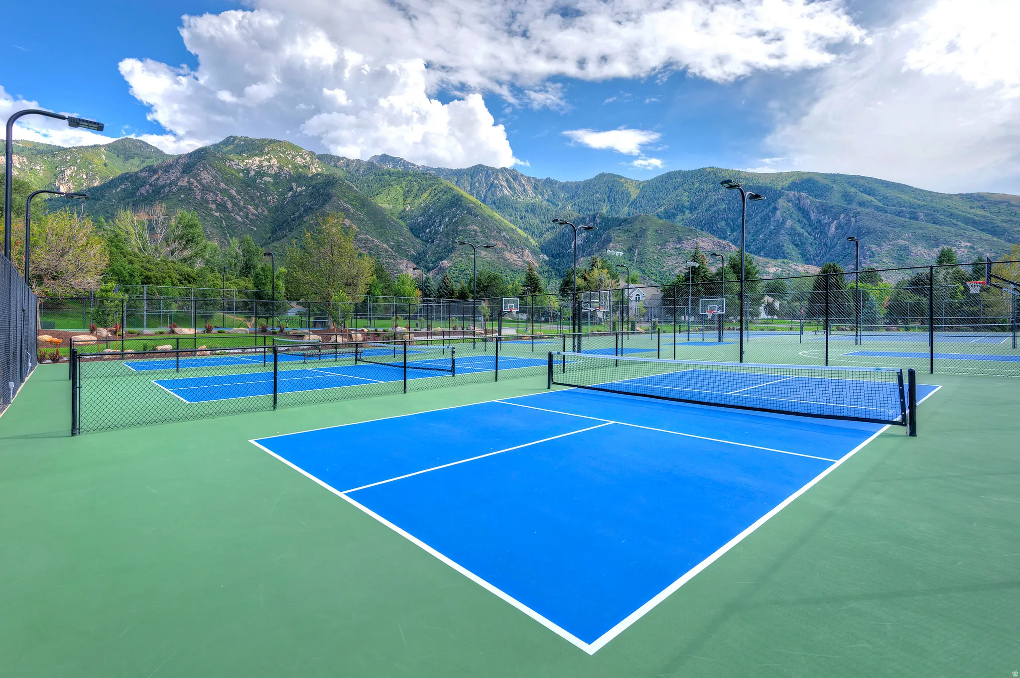 View of tennis court featuring a mountain view and community basketball court