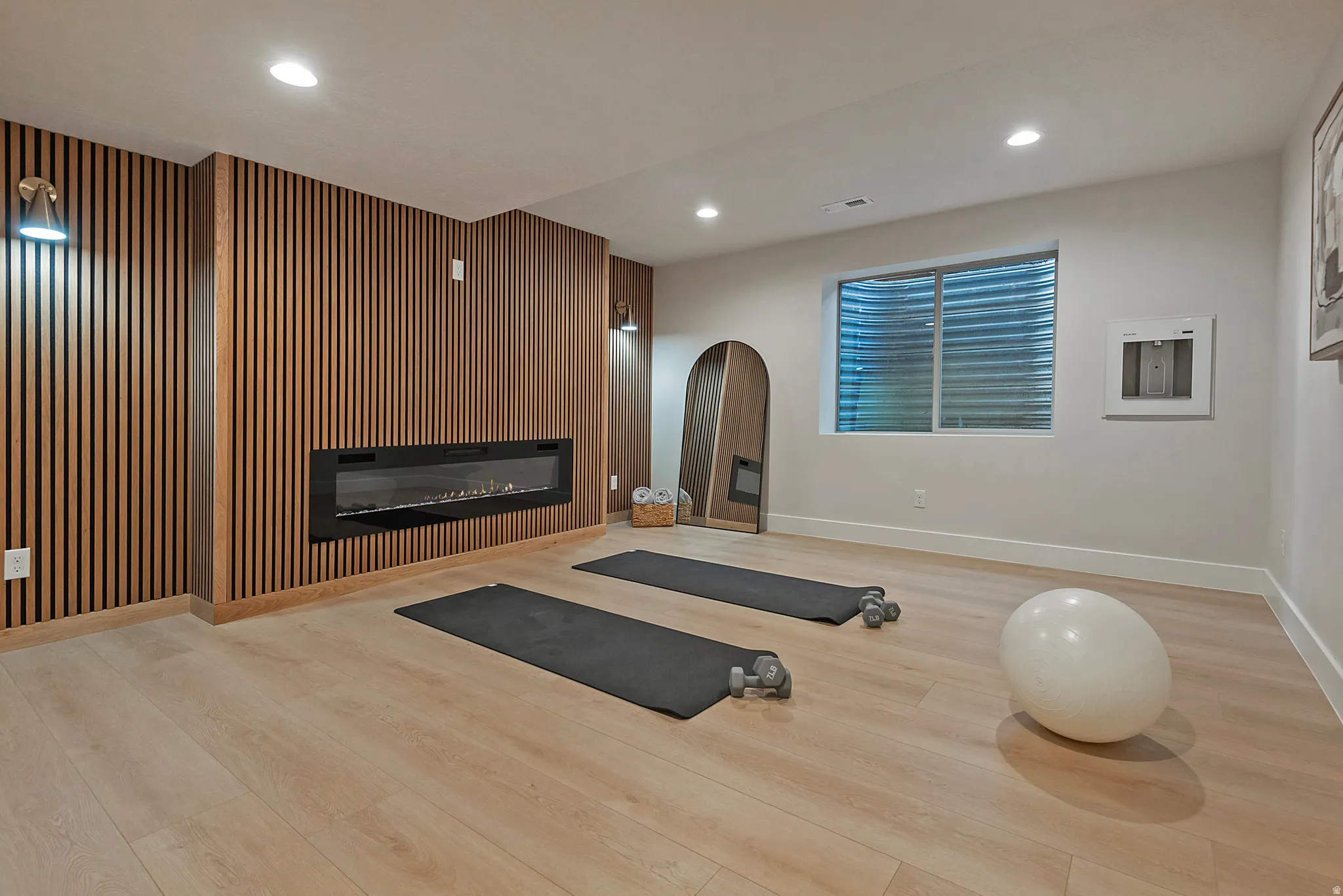 Spa like yoga room with accent wall and fireplace