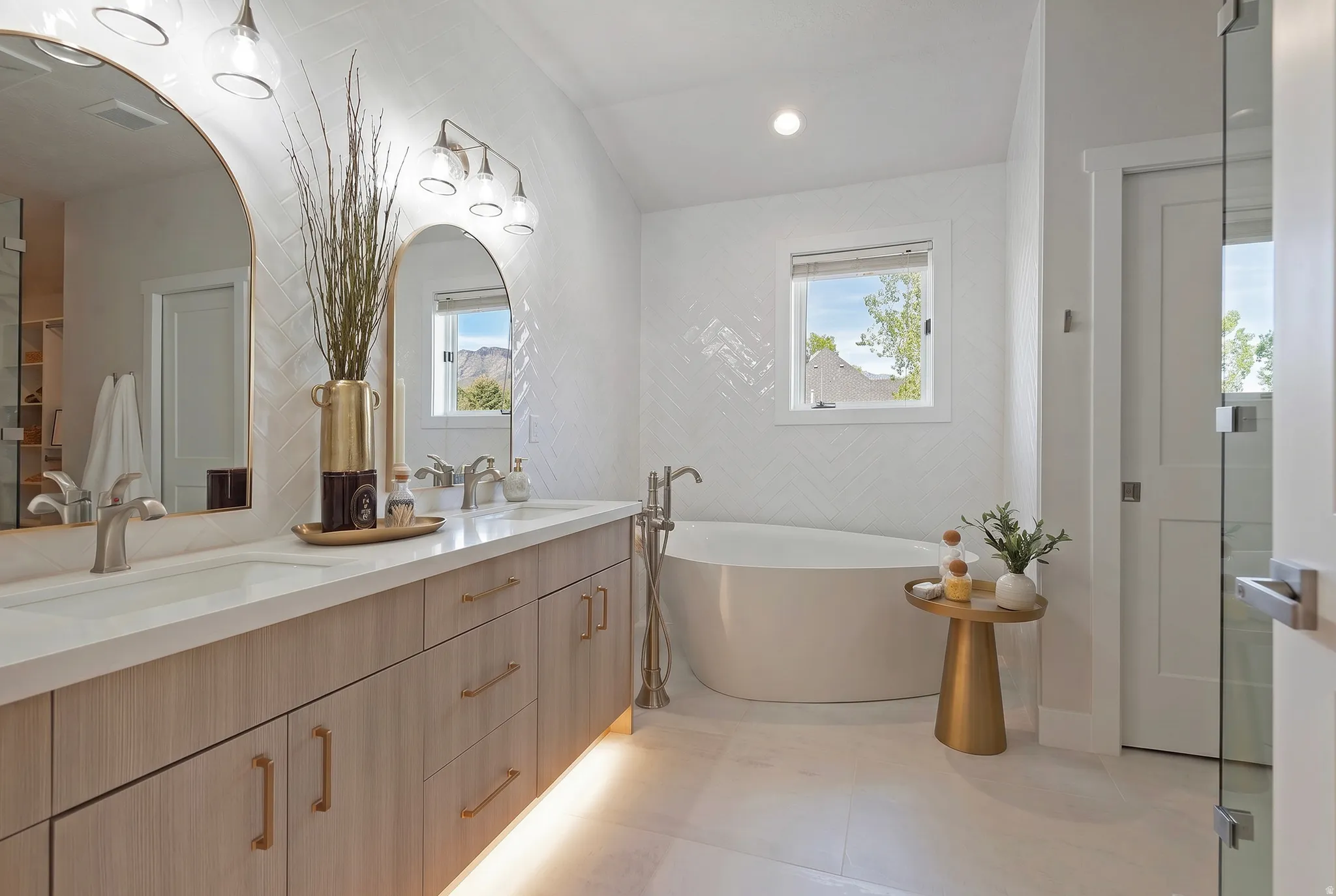 Full bath featuring double vanity, a soaking tub, healthy amount of natural light, and recessed lighting