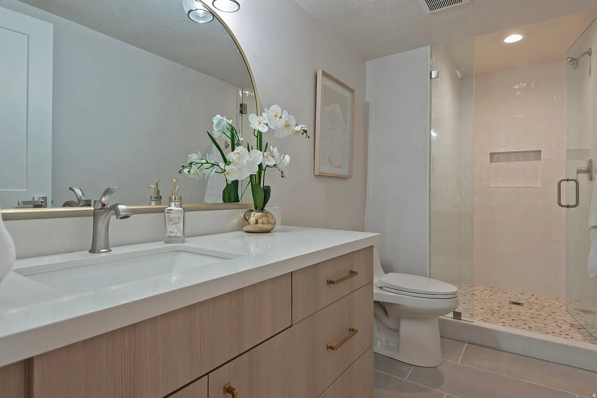 Bathroom featuring a shower stall, vanity, and light tile patterned floors