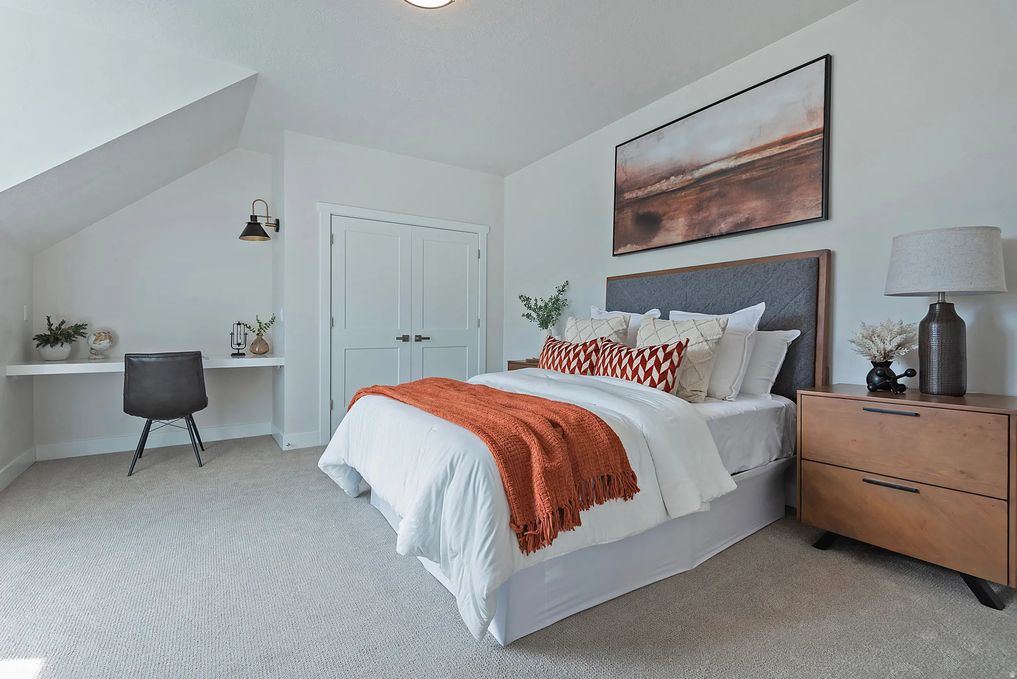 Bedroom with light colored carpet, a desk, a closet, and vaulted ceiling