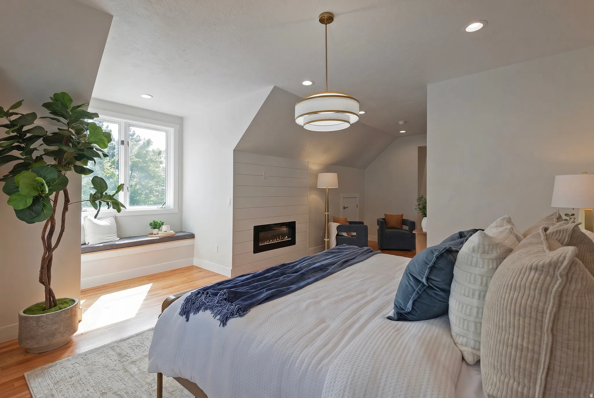 Huge primary En suite bedroom featuring vaulted ceiling, fireplace and tons of natural light.