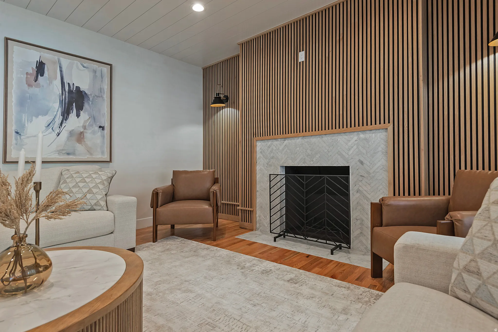 Living room with wood floors, a fireplace, recessed lighting, and wood accent walls