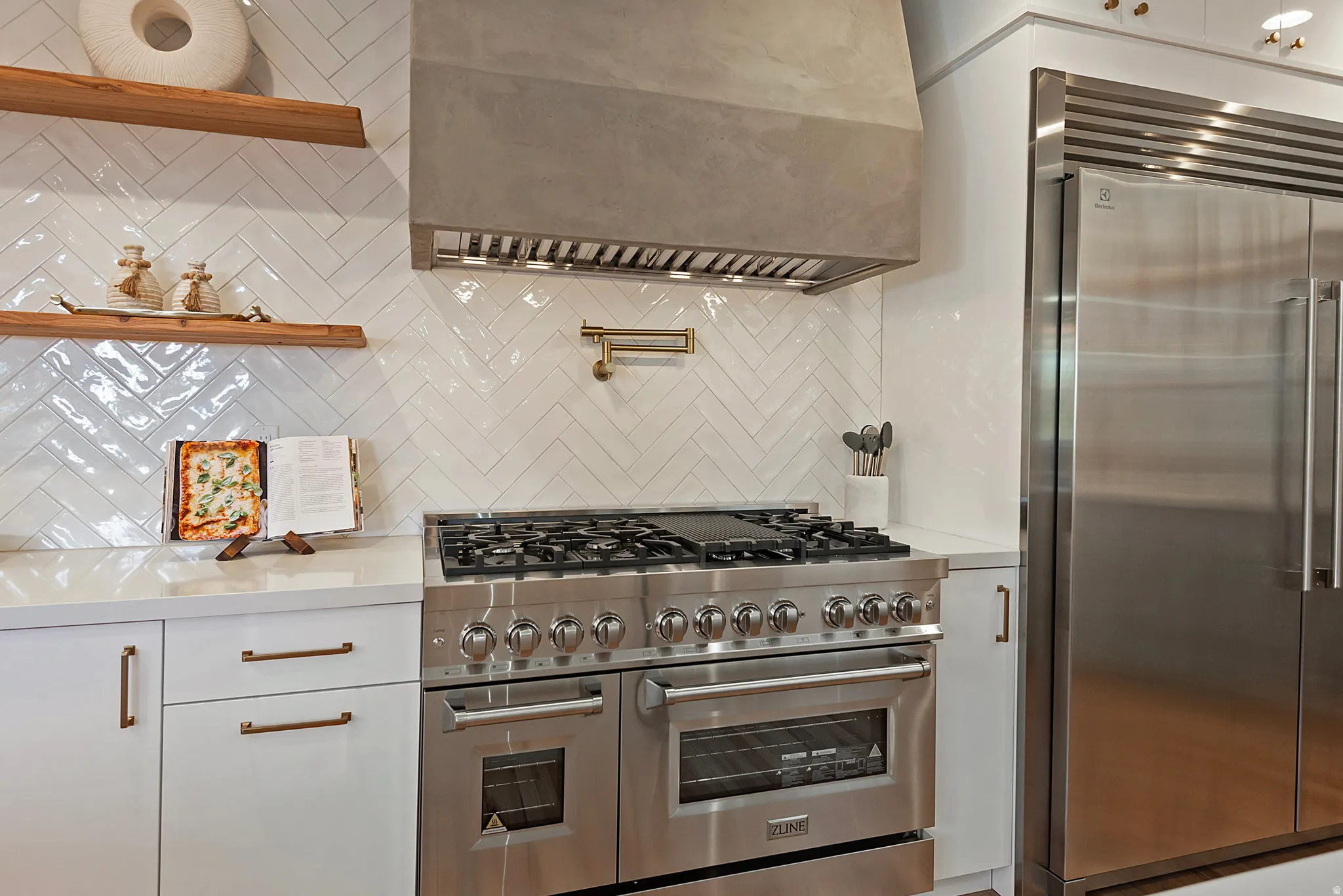 Kitchen featuring high end appliances and full wall tile.