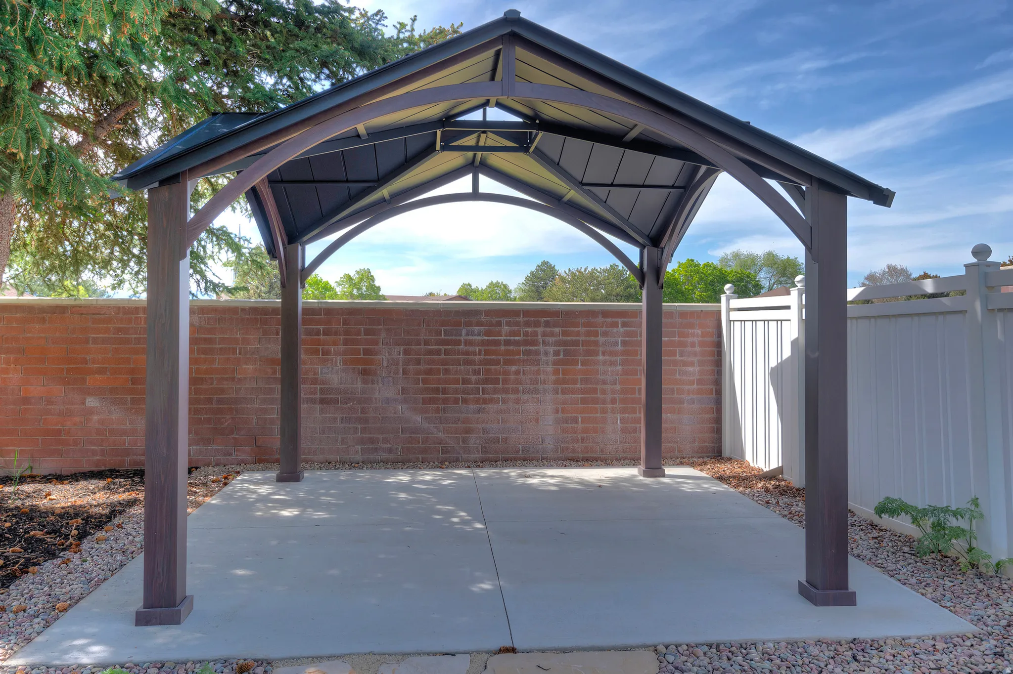 Fenced backyard featuring a gazebo and a patio