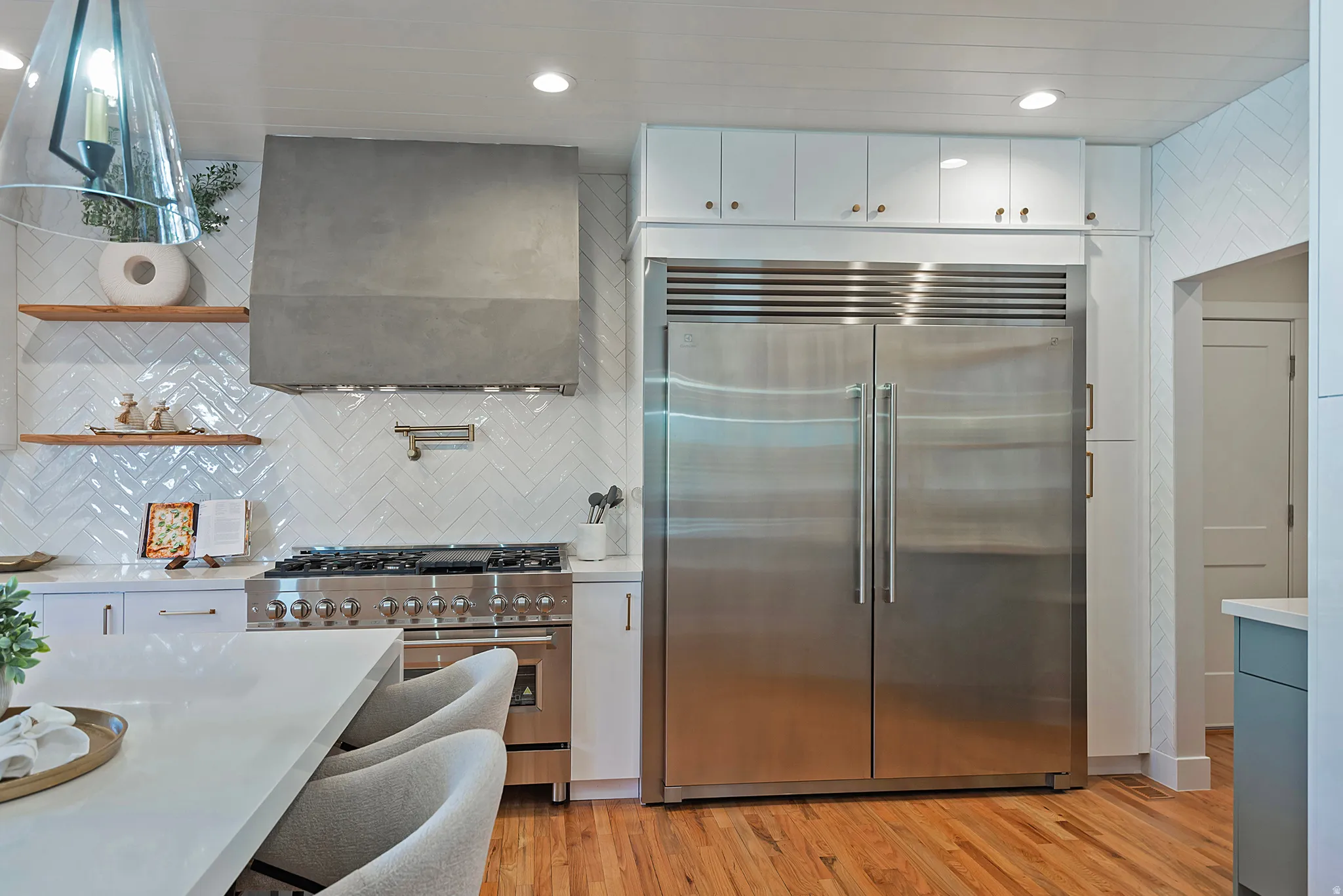 Kitchen featuring premium appliances, white cabinets, light wood-style floors, recessed lighting, and open shelves