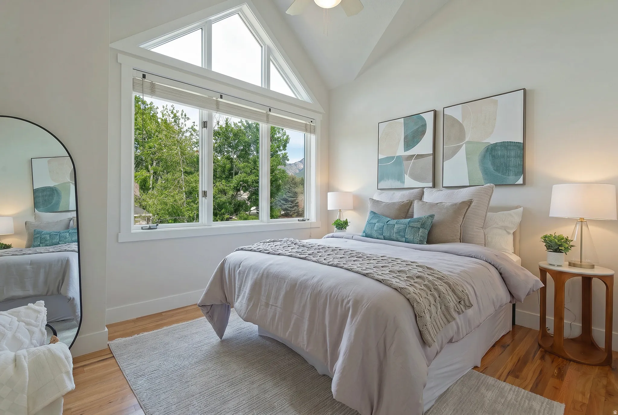 Bedroom featuring lofted ceiling, light wood-style floors, and ceiling fan, large windows
