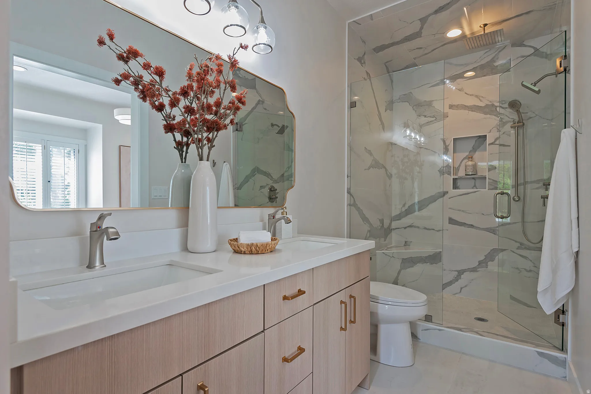 Ensuite Bathroom featuring double vanity and a marble finish shower with 2nd laundry