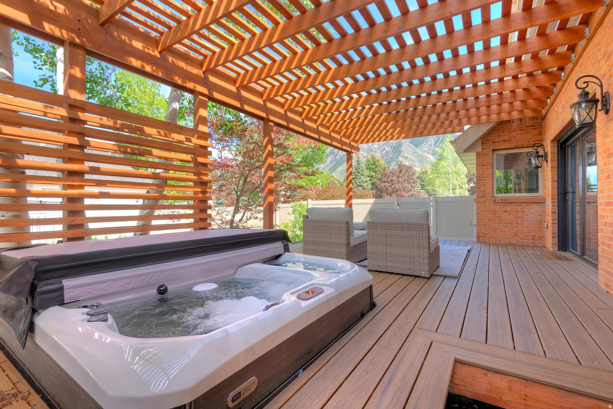 Wooden terrace with a covered hot tub and a mountain view