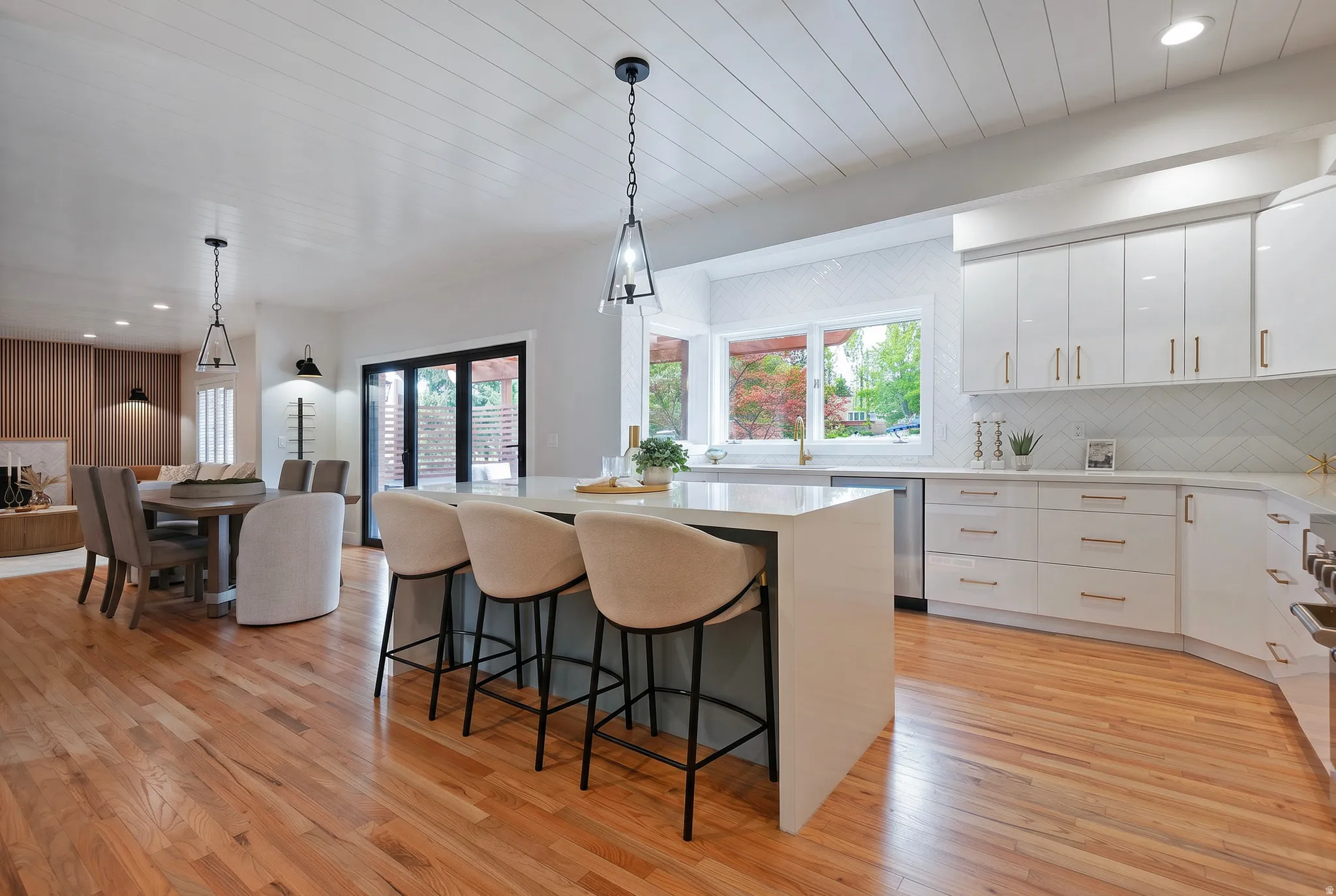 Brand new kitchen with pendant lighting, a kitchen island, backsplash, light stone counters, and wood flooring